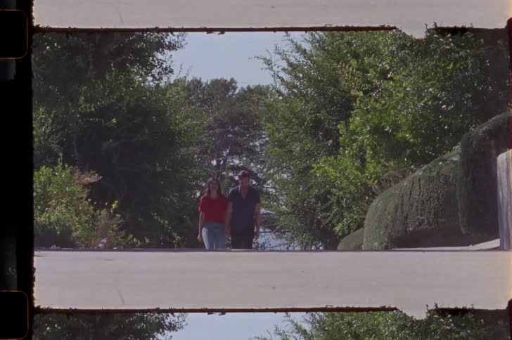 Young couple walking on a street caught on vintage film