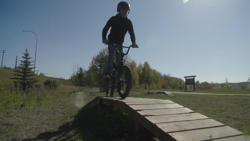 Boy riding a bicycle and going over a small ramp