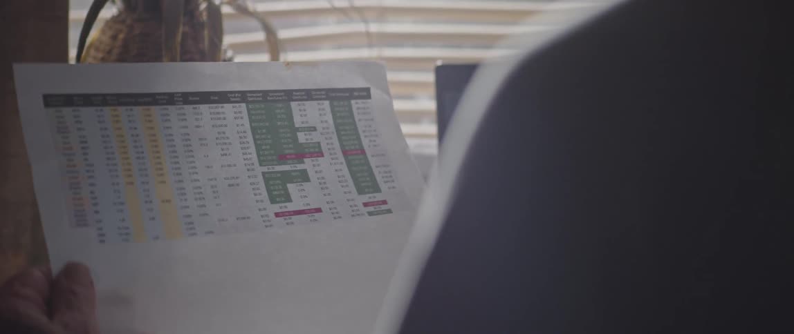 Man reading spreadsheets printed on paper