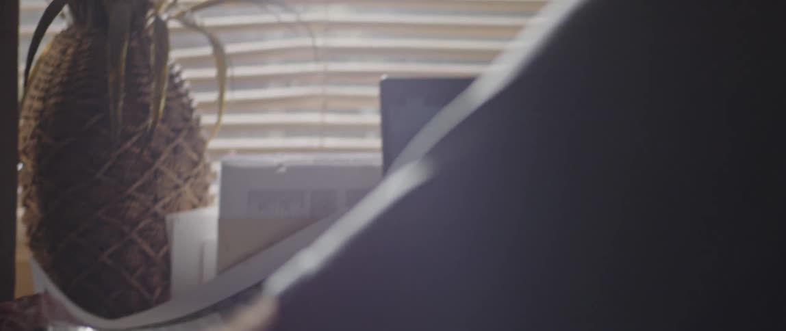 Elderly person sitting in front of their laptop holding a sheet and analyzing data