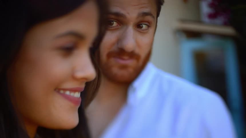 A couple talking to someone on a cell phone video call