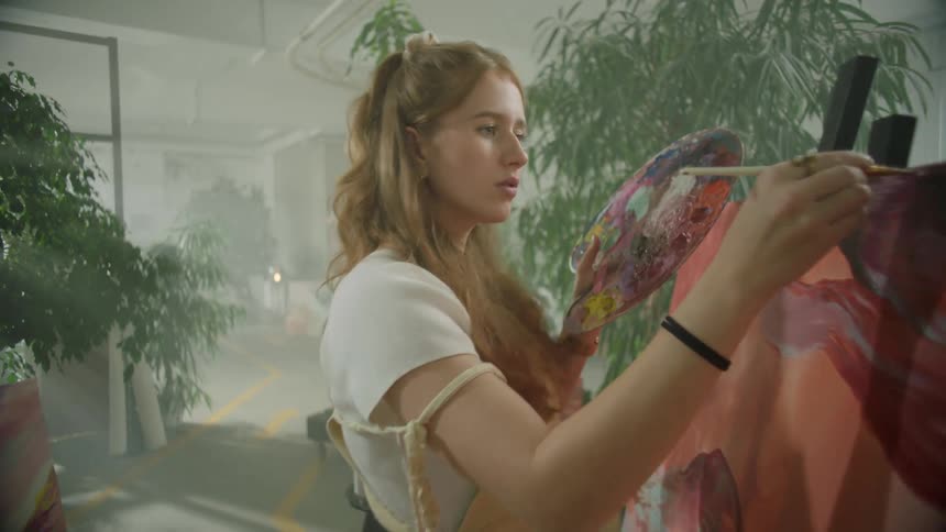 Artist painting on canvas in her studio