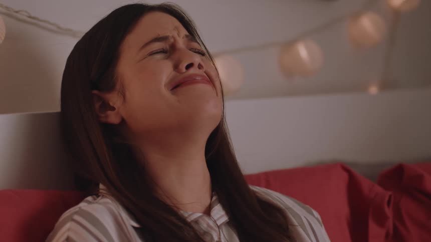 A sad girl crying alone in her room