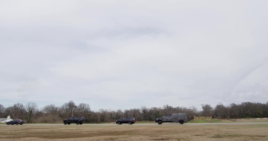 Police vehicles drive down the road