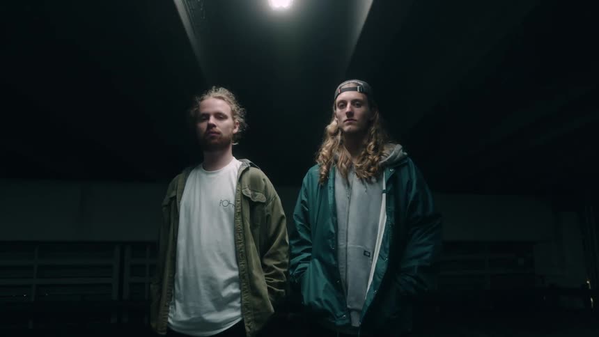 Two men stand in the dark parking garage