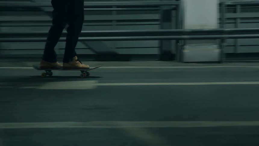 A man is skateboarding through a parking lot