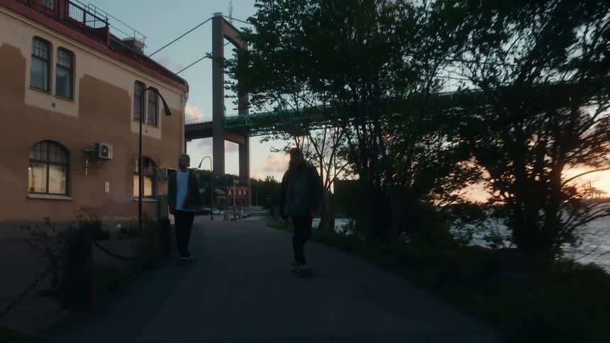 Male skateboarders ride skateboards along promenade in the city