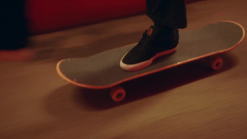 A man rides a skateboard indoors