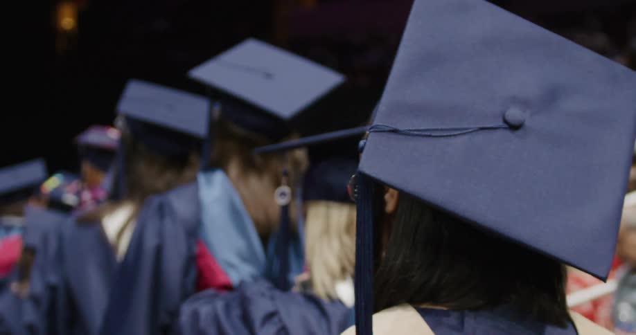 High school students in full uniform in line to receive their graduation diplomas