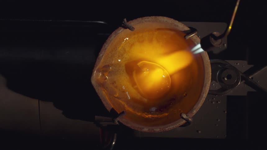 A blowtorch is setting fire to a piece of glass and melting it to shape it
