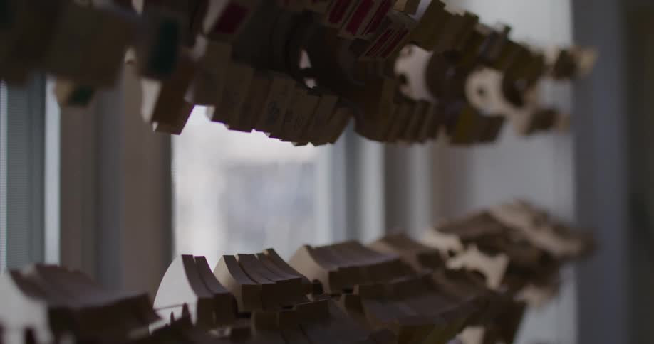 Abstract wooden objects hanging on a string next to the window