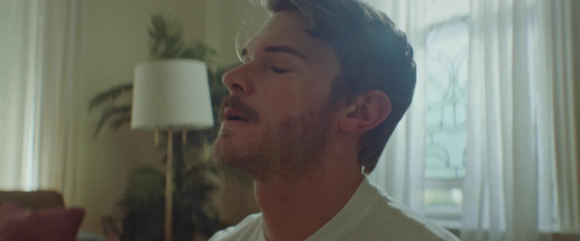 A man sits down and takes a deep breath