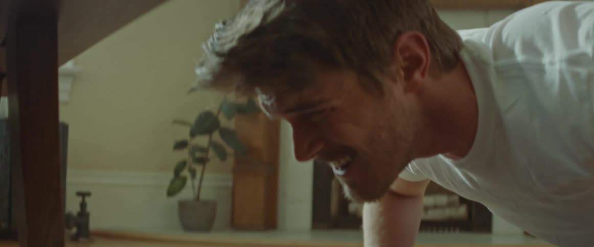A man is exercising inside of a house