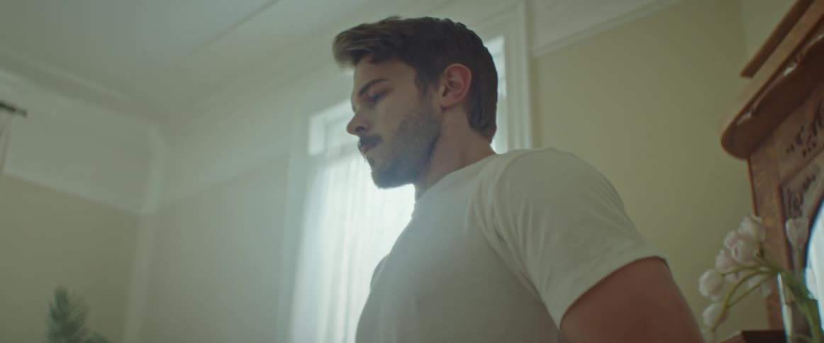 A man paces back and forth in his living room looking concerned