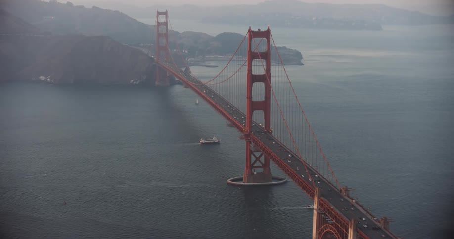 Aerial panorama of the Golden Gate Bridge spanning the San Francisco Bay with vehicles moving across