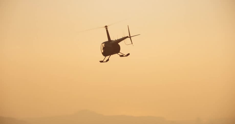 An helicopter flying at sunset