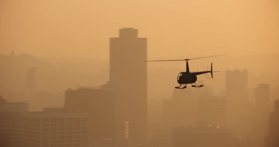 Panorama of a helicopter flying over San Francisco with fog at sunset