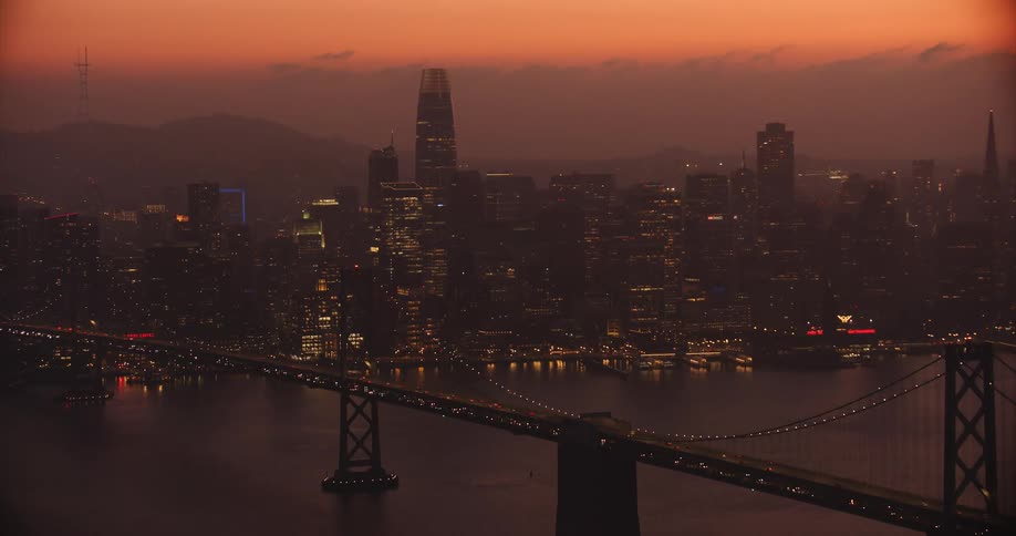 San Francisco, Aerial of the city and Bay Bridge during sunset with illuminated skyscrapers