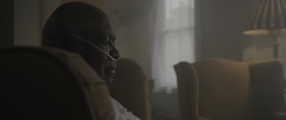 An elderly man napping in a chair