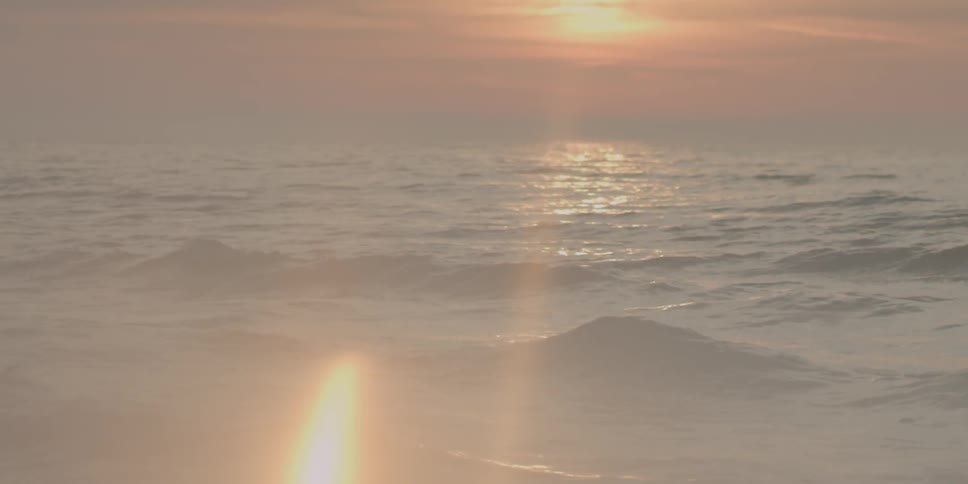 The sun sets over ocean waves