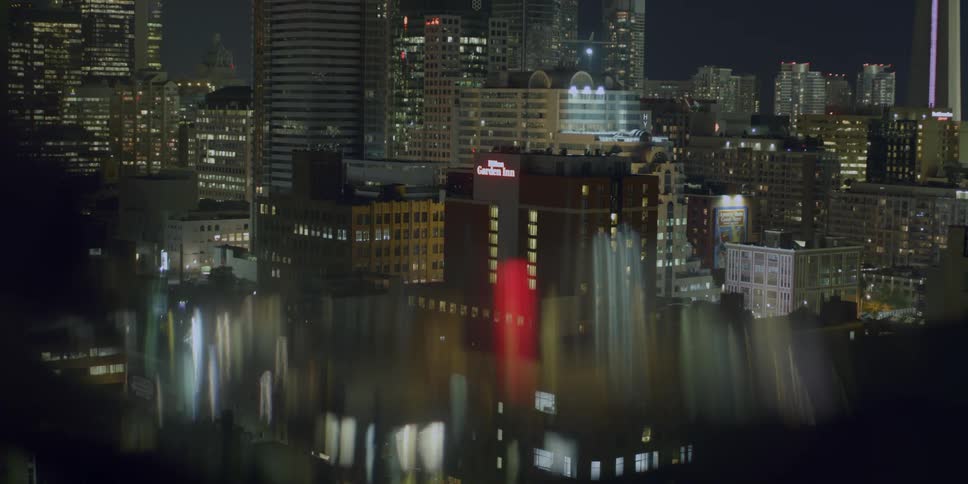 Blocks of downtown buildings showing lights turning on and off