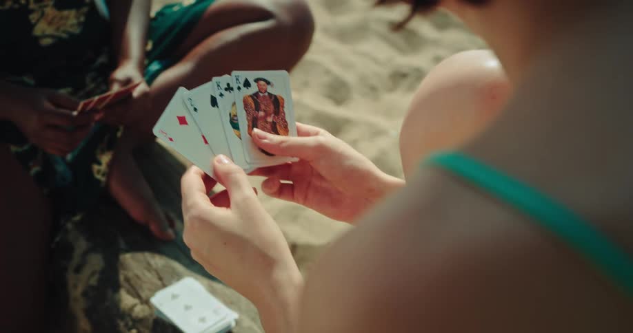 Friends playing carts on the sand beach
