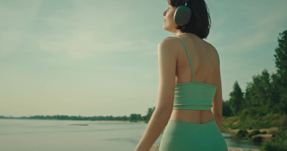 A woman is listening to music on her headphones and dancing