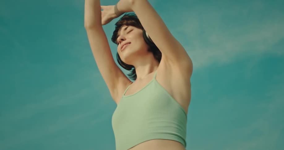 Woman enjoying music in the sand with her headphones