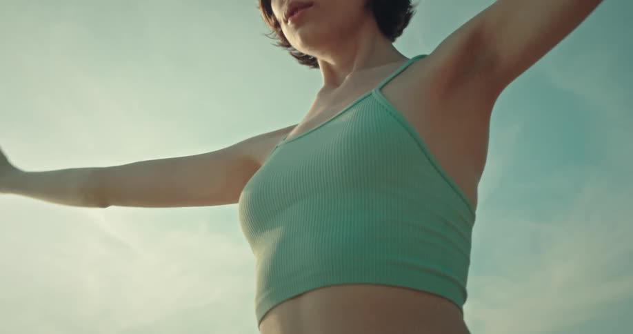 A young woman is raising her arms and doing yoga poses