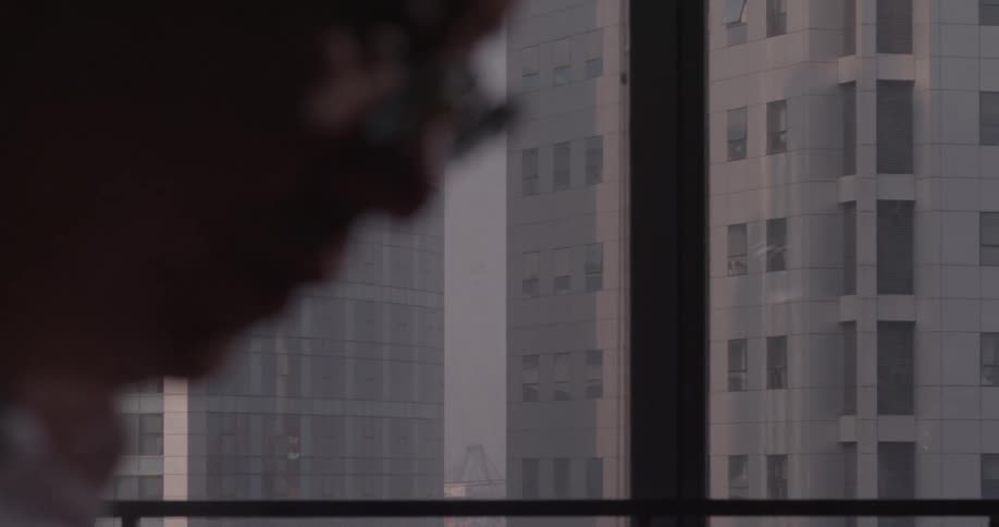 Man with glasses looks down at something