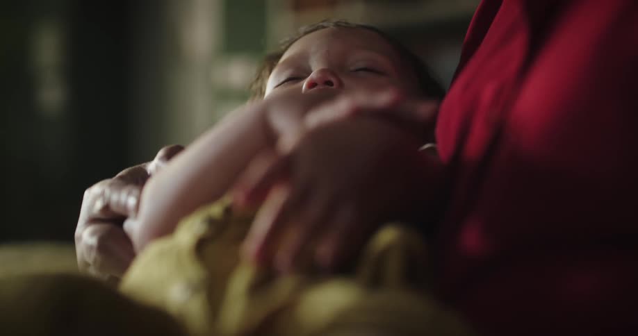 Grandmother holding a sleeping baby on her lap