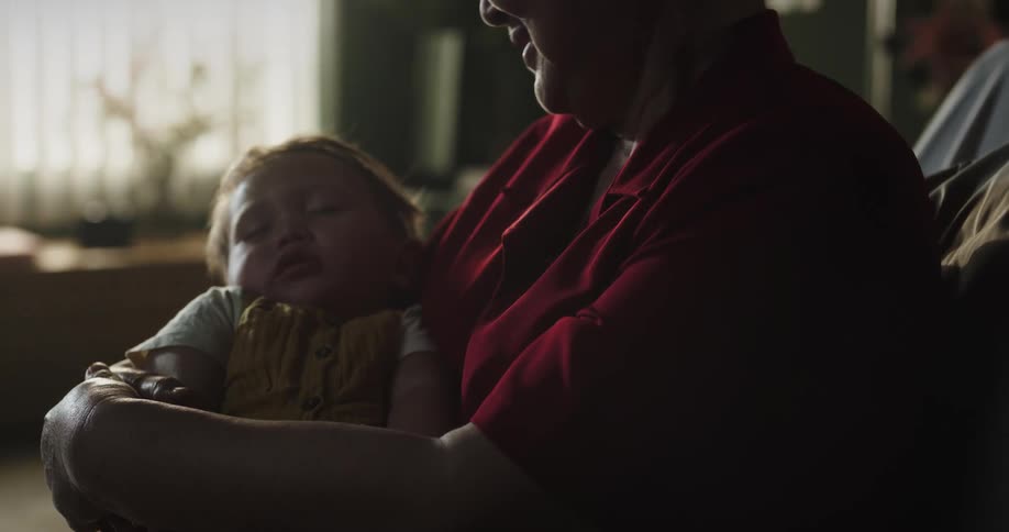 Grandmother holding a sleeping baby in her lap