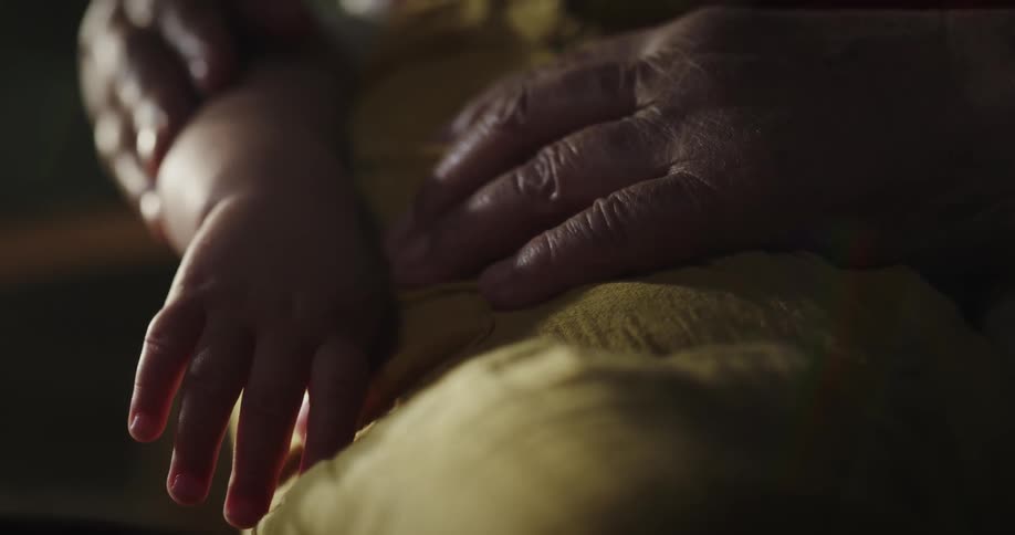 Grandparent holds their grandchild as they sleep
