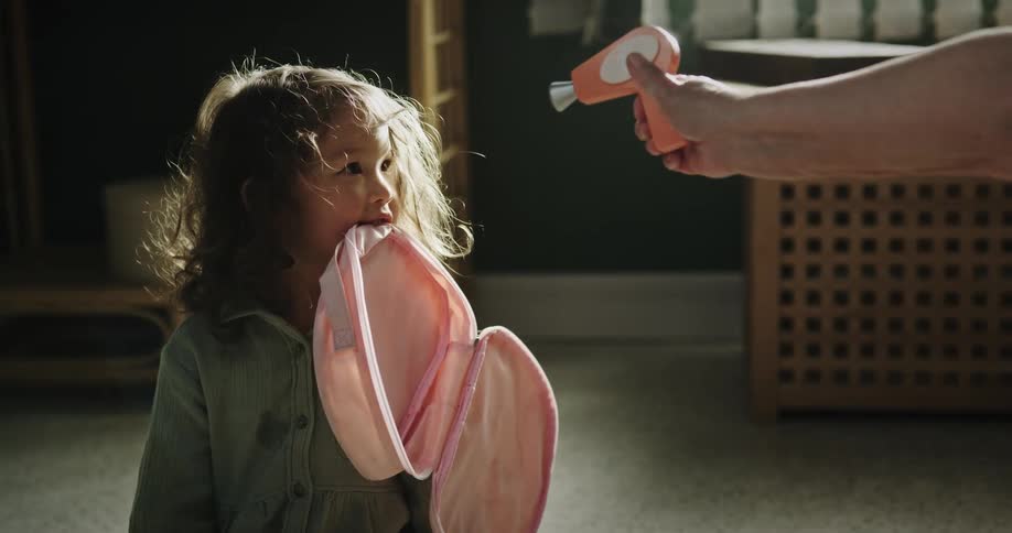 A person playing with a child with atoy