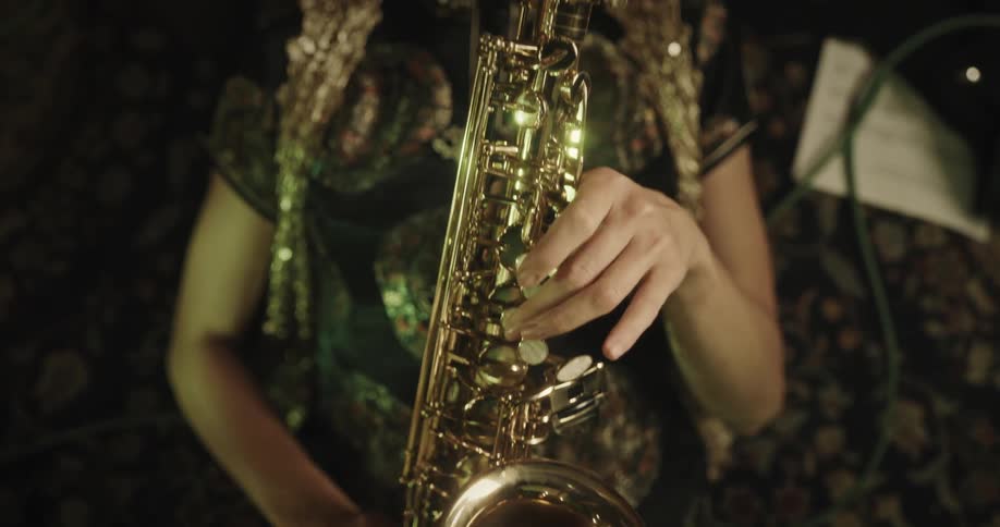 Female musician puts down sheet music then plays saxophone