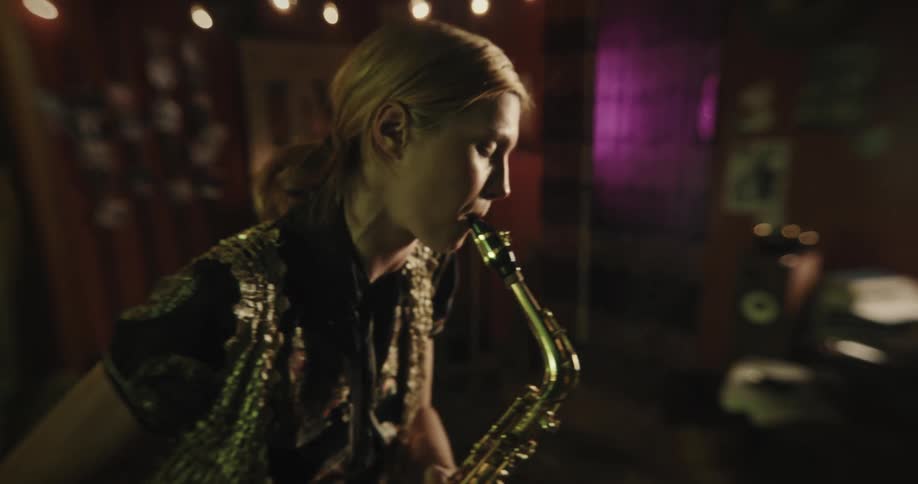 Woman passionately plays her saxophone in a club