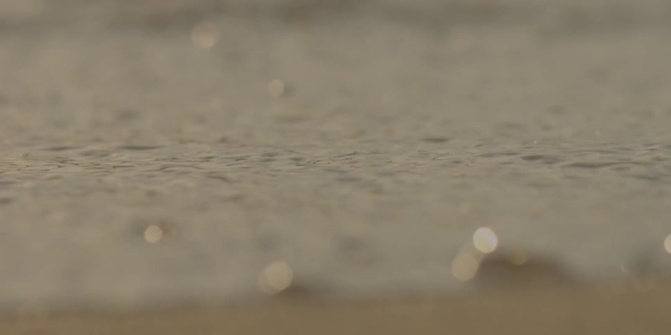 Water splashes up on a sandy beach