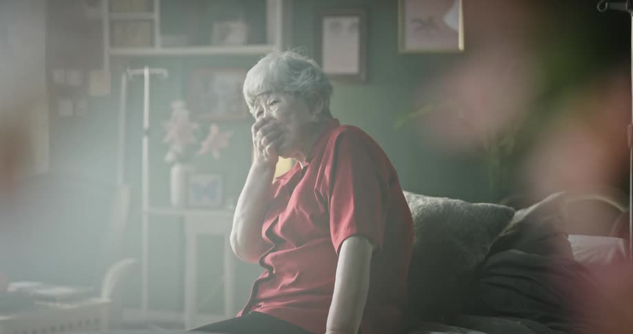 An elderly woman smiles and talks to a young child playing on the floor