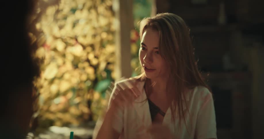 A young woman smiles as she talks and gestures excitedly