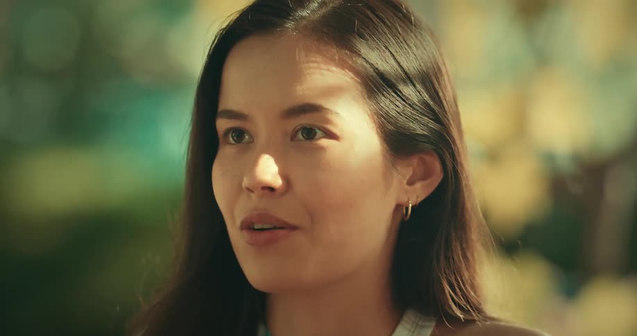 Closeup of a womans face talking animatedly outdoors