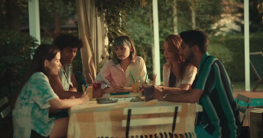 Friends sitting at a table talking and playing