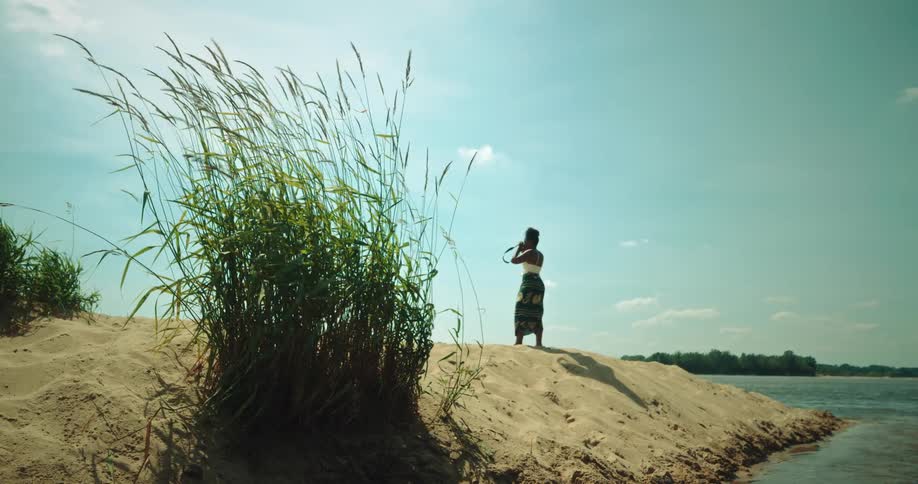 A woman on the beach observes the landscape with binoculars