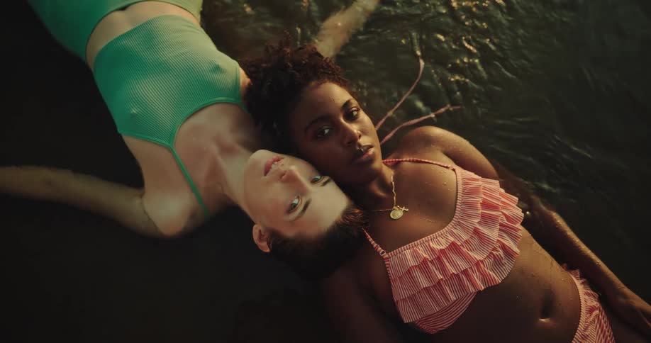 Two women lay in the water together