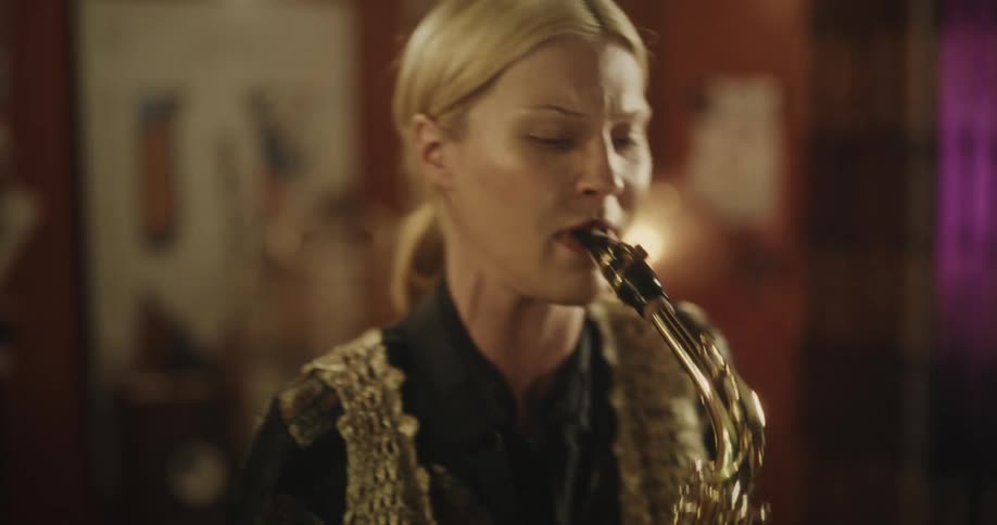 A woman playing a saxophone passionately