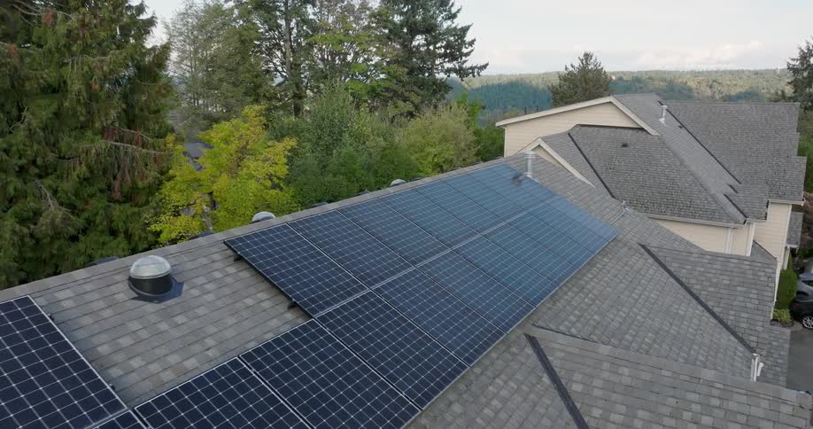 Pullback reveal of solar panels installed onto a gray shingle roof