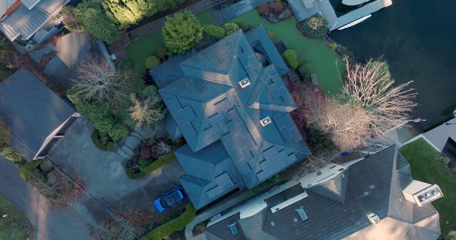 Descending towards an upscale home with high wattage solar panels covering the roof