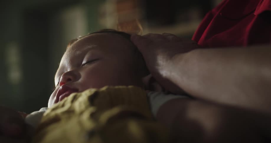 Grandmother gently stroking her granddaughters hair as she sleeps in her lap