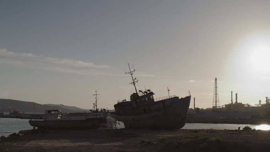 Ship stranded amidst the land next to the sea
