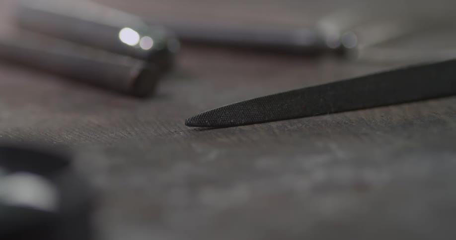 A metal file lays on a table