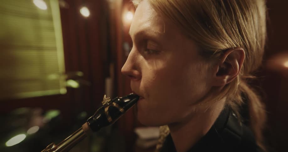 Portrait of a young woman playing a trumpet indoors